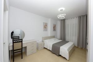 a bedroom with a bed and a desk and a television at Sara apartment in Vlorë