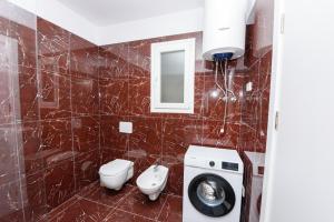 a bathroom with a toilet and a washing machine at Sara apartment in Vlorë +25 photos