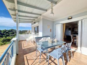 a patio with a table and chairs on a balcony at Seaview Villa with Pool for 6 in Porto Heli