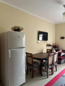 Una cocina con una mesa y un refrigerador blanco. en Adriatic Escape, en Durrës