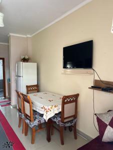 comedor con mesa, sillas y nevera en Adriatic Escape, en Durrës