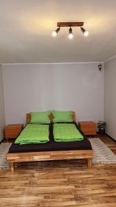 a bedroom with a bed with green pillows on it at PGL in bucataria mamei- cazare la tara in Mălîncrav
