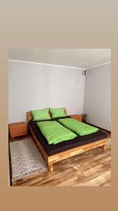 a bedroom with a bed with green pillows on it at PGL in bucataria mamei- cazare la tara in Mălîncrav