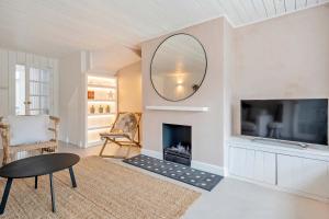 a living room with a fireplace and a mirror at Chic Coastal Retreat - 5-Min Stroll to Beach in West Wittering