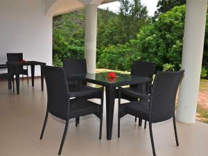 a black table and chairs on a patio at Wyn Villa in Anse Possession