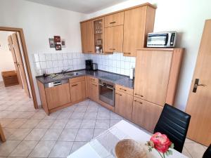 a small kitchen with wooden cabinets and a microwave at Ferienhaus Leonie in Barth +11 photos