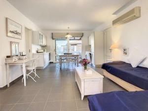 a room with a bed and a kitchen with a table at Beach Villa, Swimming pool for 8 in Thermisia