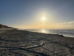 a beach with people walking on the sand and the ocean at 6 person Holiday Inn in Hvide Sande +2 photos