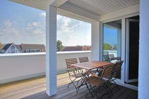 a table and chairs on a balcony with a large window at Villa Baltic Star in Börgerende-Rethwisch