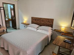 a bedroom with a large white bed with two lamps at Pousada do Alferes in Paty do Alferes