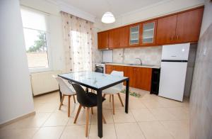 a kitchen with a table and chairs in a kitchen at Boskos Apartments in Asprovalta