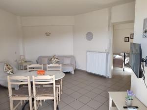 a living room with a table and chairs and a couch at Nea Kydonia suites and studios in Daratso