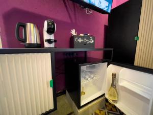 a small refrigerator with a bottle of wine in it at Residencia Barrio B&b - 3 suites - 6 Minutes from Amalfi Coast in Cava deʼ Tirreni +65 photos