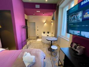 a room with a bed and a flat screen tv at Residencia Barrio B&b - 3 suites - 6 Minutes from Amalfi Coast in Cava deʼ Tirreni