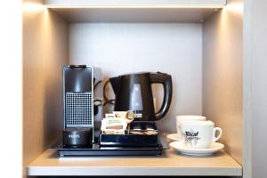 a shelf with a coffee maker and cups on it at Hotel Cap Negret in Altea