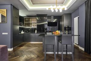 a kitchen with a bar with two stools at F&B Spa Resort (ex. Fomich Hotel) in Bukovel