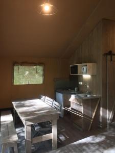 a small kitchen with a table and a microwave at Camping du Domaine de Clarat in La Celle-sous-Gouzon +3 photos