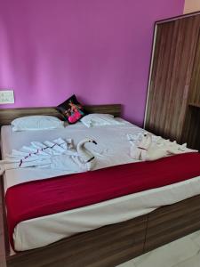 una cama con animales de peluche con una pared rosa en Gharkul guest house, en Calangute