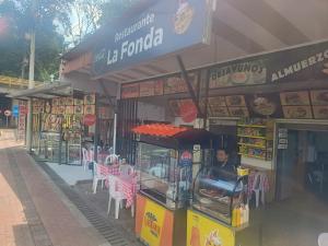 a food stand with pink tables and chairs in front of a store at La fonda in Santa Rosa de Cabal