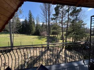 a balcony with a view of a field and trees at Willa Powroty in Zakopane