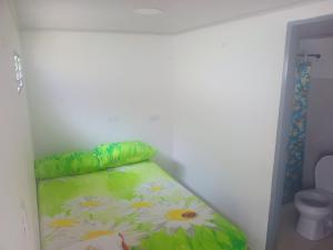 a small bedroom with a bed with flowers on it at La fonda in Santa Rosa de Cabal