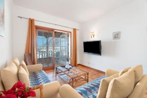 a living room with a couch and a tv at Gigantes Apartament Sea View in Acantilado de los Gigantes