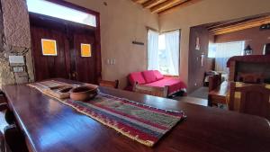 ein Wohnzimmer mit einem Holztisch und einer Couch in der Unterkunft Cabañas Mallma in Tilcara