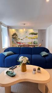 a living room with a blue couch and a table at Grand Appartement 2 chambres et 2 SDB, Balnéo, Centre-ville in Quimper