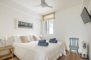 a bedroom with a white bed with two stuffed animals on it at Fantastic beach apartment near Valencia in Valencia