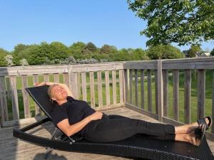 a man laying on a hammock on a deck at Gilleleje Camping in Gilleleje +17 photos