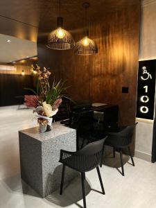eine Lobby mit Tisch, Stühlen und Beleuchtung in der Unterkunft Otto Hotel in Governador Valadares + 18 Fotos
