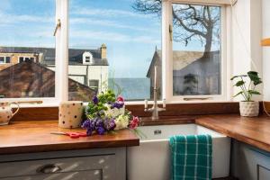 a kitchen with a counter with a sink and windows at Beach Approach House - 30 steps from beach - Luxury house - kids slide and chill-out room - amazing location - garden in Filey