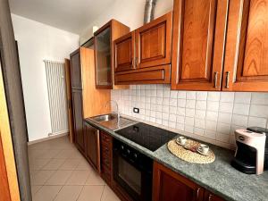 a kitchen with wooden cabinets and a counter top at SuiteSigismondo-L'appartamento Più Centrale Di Rimini in Rimini