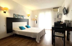 een slaapkamer met een bed met blauwe kussens erop bij SAINT FLORENT - Studio 3 pers balcon vue mer FLO127 in Saint-Florent