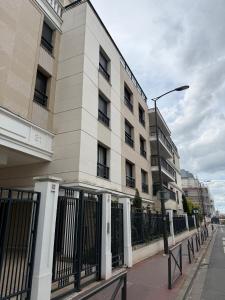 a building on a street with a fence and a street light at La chatillonnaise in Châtillon
