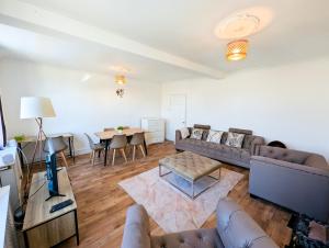 a living room with a couch and a table at Cozy 2BR Flat Near Twickenham Stadium for Families in Teddington