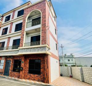 Xinwu遇见126 包栋民宿的街道上带阳台的砖砌建筑