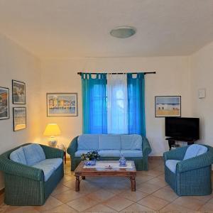 a living room with two blue couches and a coffee table at Villa Pina 100 meters from the sea in Fort Village +13 photos