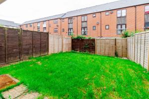 a backyard with a fence and green grass at Contractors Wow! 5 Bedrooms 10 Guests Free Parking in Basingstoke
