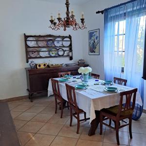 a dining room with a table with chairs and a chandelier at Villa Pina 100 meters from the sea in Fort Village