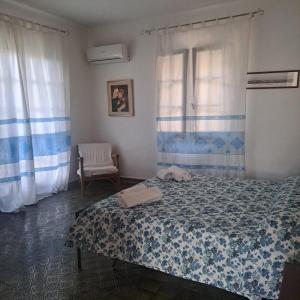 a bedroom with a bed and a chair and a window at Villa Pina 100 meters from the sea in Fort Village