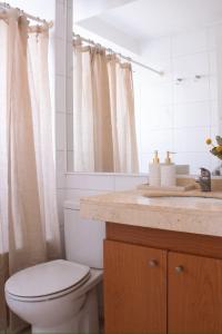 a bathroom with a white toilet and a sink at Depto de lujo en Avenida Kennedy, cerca de Clinica Alemana in Santiago +13 photos