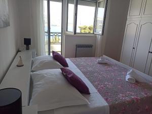 two beds in a room with two windows at Apartment Tea 1 in Okrug Donji