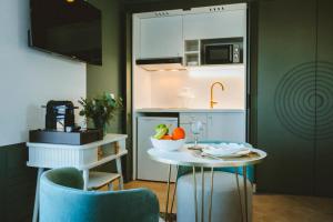 a kitchen with a table with a bowl of fruit on it at Le Berceau de La Source in Bagnères-de-Bigorre