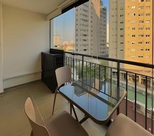 a balcony with a glass table and chairs at Atmosfera Hachi 416I Luz Natural & Conexão Elevada in Sao Paulo