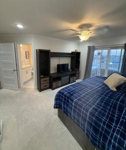 a bedroom with a blue plaid bed and a television at Paradise on Paradise Way in North Wildwood