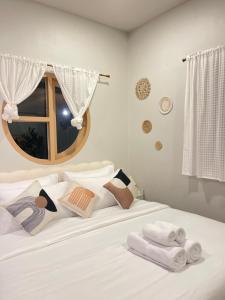 Ban Laem Muangにあるอุ่นไอดิน Home Stayの白いベッド(タオル付)が備わります。