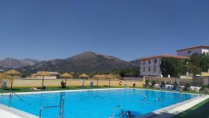 a large blue swimming pool with mountains in the background at B&B Villa Deseada in Periana