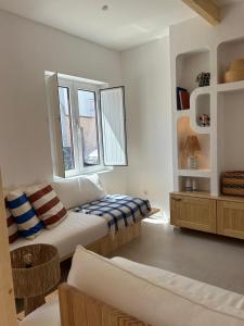Un dormitorio con una cama y un sofá y ventanas. en Casa Dar Alma, en Vila Real de Santo António