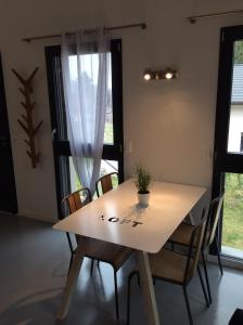 une table et des chaises dans une pièce avec fenêtres dans l'établissement Studio Lac et Tournette, à Saint-Jorioz